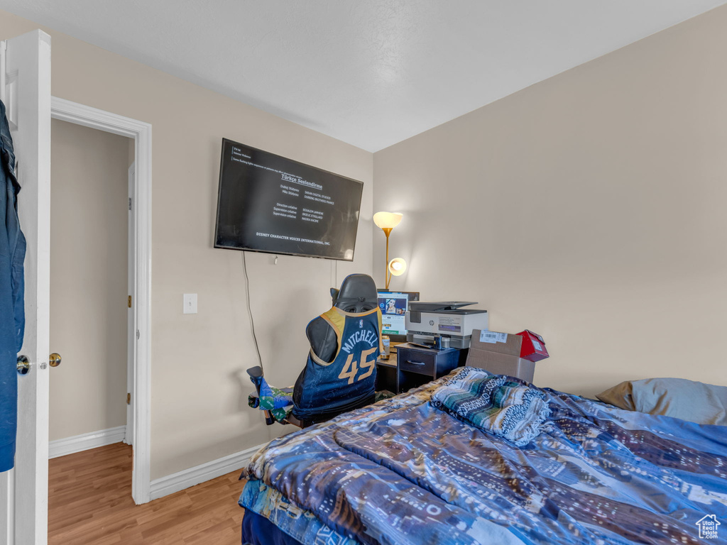 Bedroom featuring wood finished floors and baseboards