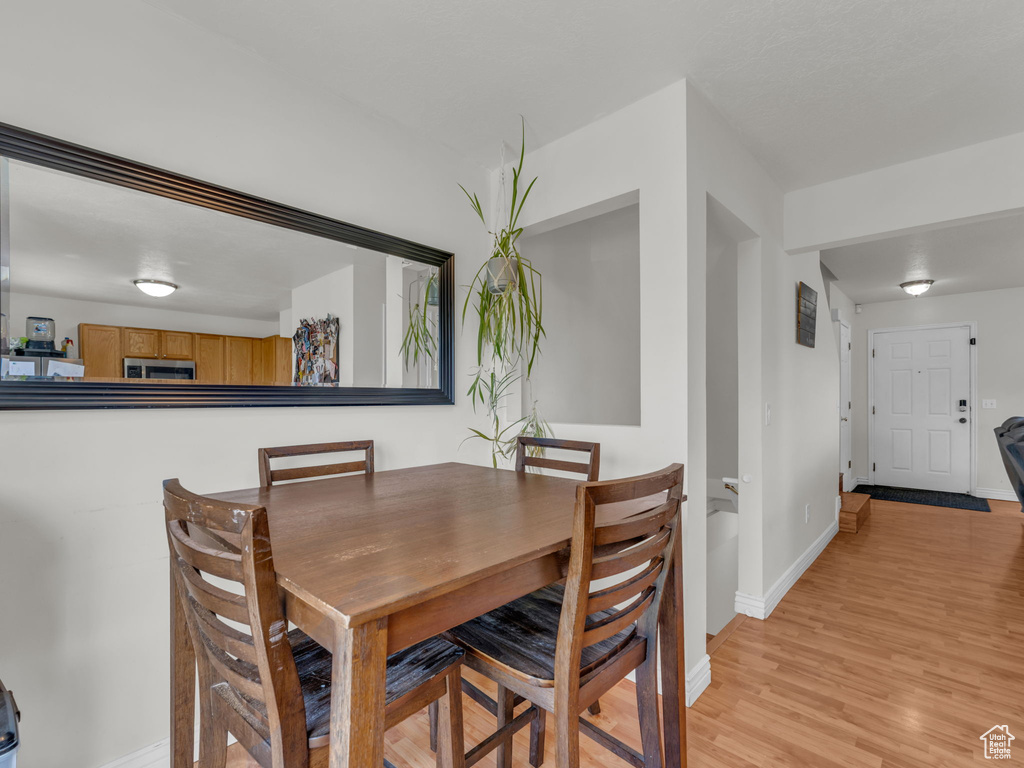 Dining area with baseboards and light wood-style floors