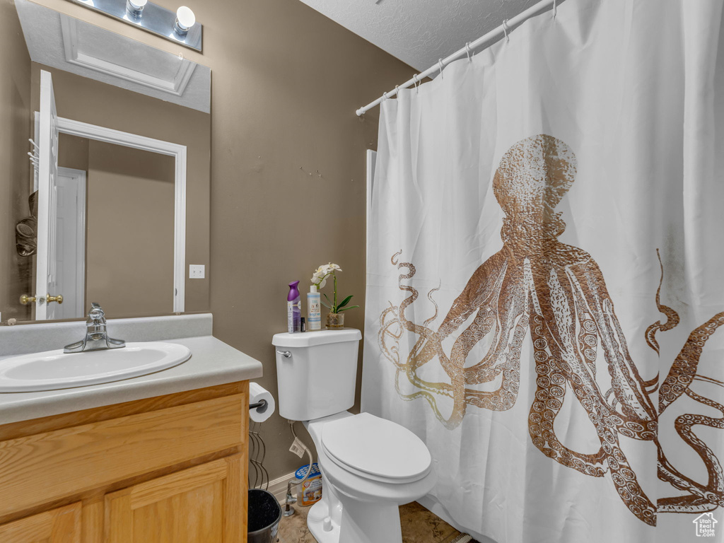 Full bath with vanity, toilet, baseboards, and a shower with shower curtain