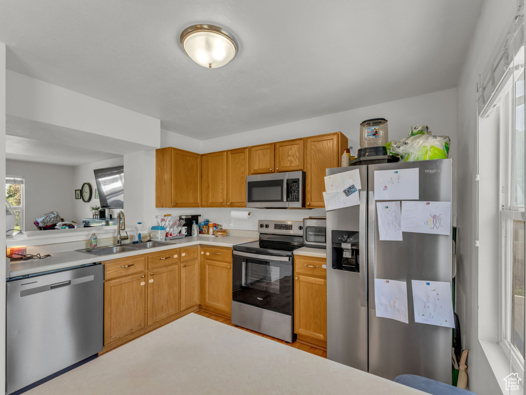 Kitchen featuring stainless steel appliances, a sink, and light countertops