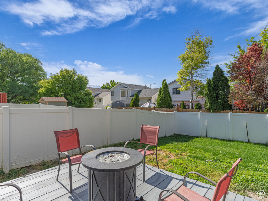 Wooden deck featuring a fire pit and a residential view