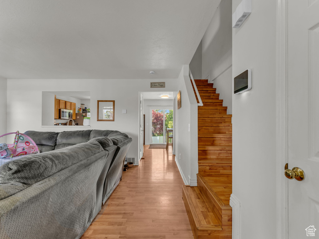 Living area with light wood-type flooring and stairway