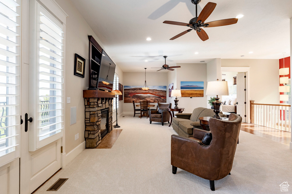 Carpeted living area featuring a ceiling fan, recessed lighting, a fireplace, and baseboards