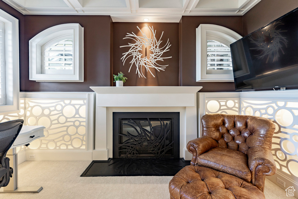 Carpeted living area with a glass covered fireplace and coffered ceiling