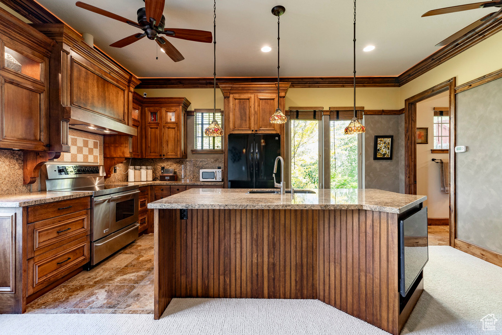 Kitchen featuring stainless steel range with electric stovetop, a ceiling fan, freestanding refrigerator, range hood, and crown molding