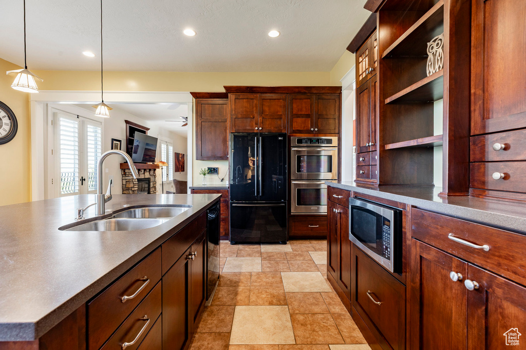 Kitchen featuring black appliances, a sink, open shelves, decorative light fixtures, and recessed lighting