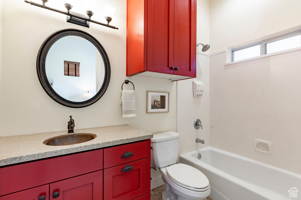 Bathroom featuring toilet, vanity, and bathtub / shower combination