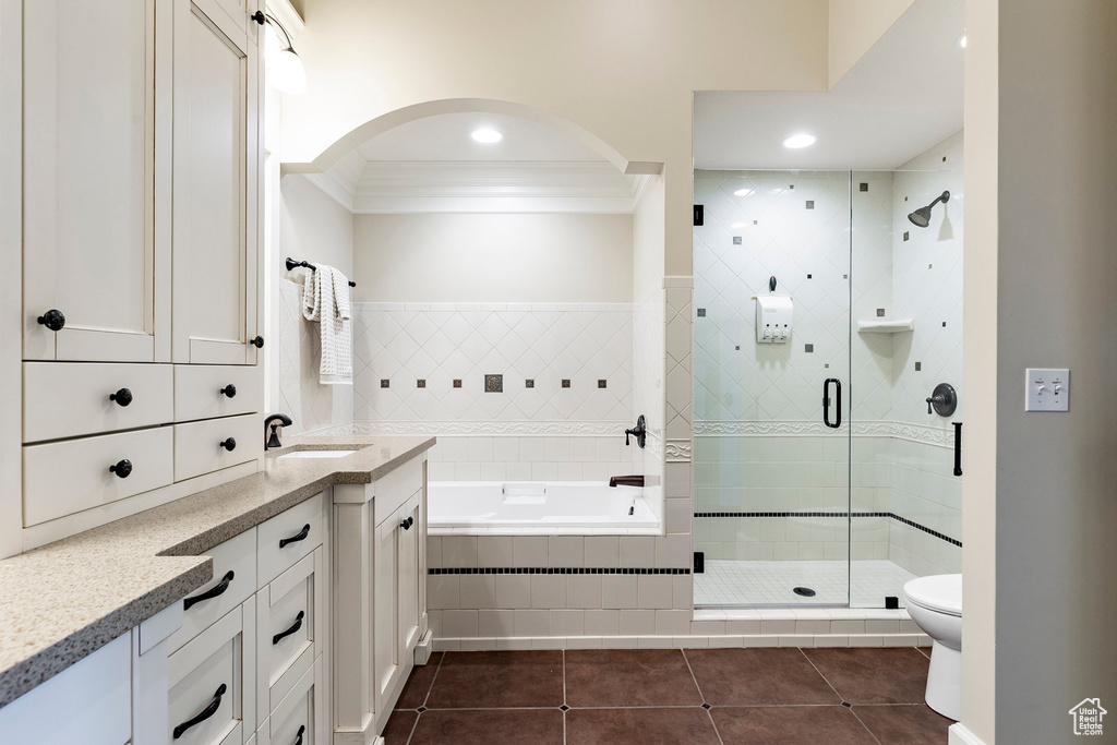 Full bathroom with tile patterned flooring, vanity, a garden tub, ornamental molding, and a stall shower