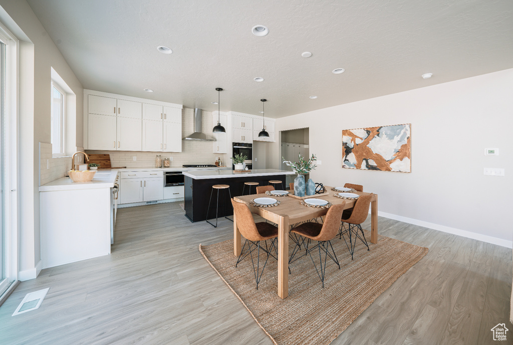 Dining space with light wood-type flooring, recessed lighting, and baseboards