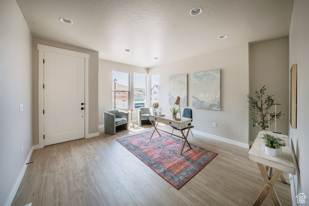 Office space with light wood-type flooring, baseboards, a textured ceiling, and recessed lighting
