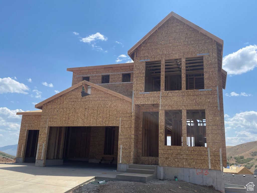 Property in mid-construction featuring concrete driveway, a mountain view, and an attached garage