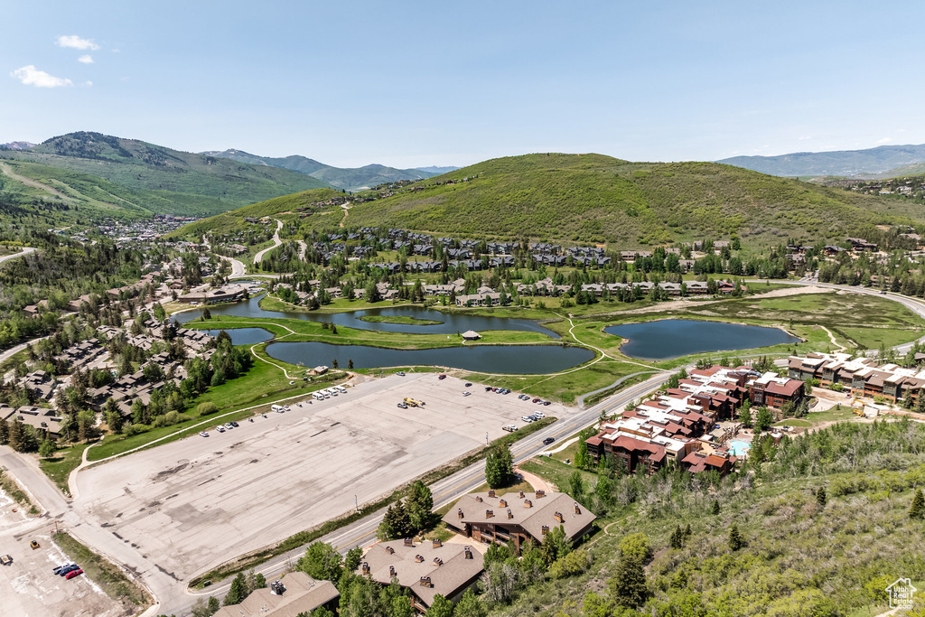 Aerial view of property's location with a water and mountain view and nearby suburban area