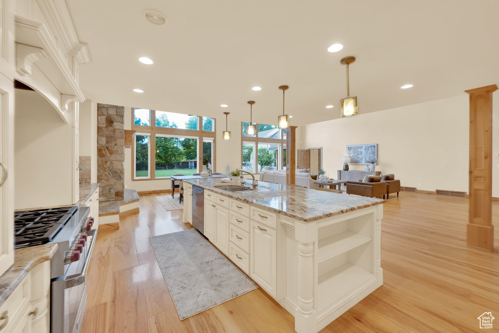 Kitchen with appliances with stainless steel finishes, ornate columns, a sink, open shelves, and recessed lighting