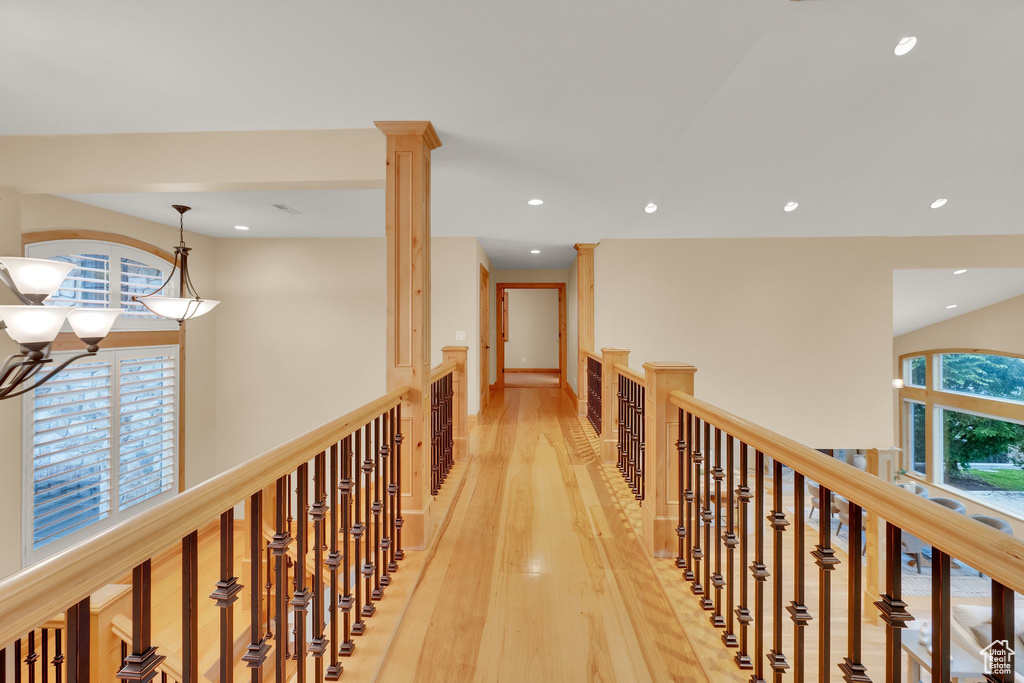 Corridor featuring light wood-style flooring, recessed lighting, and a chandelier