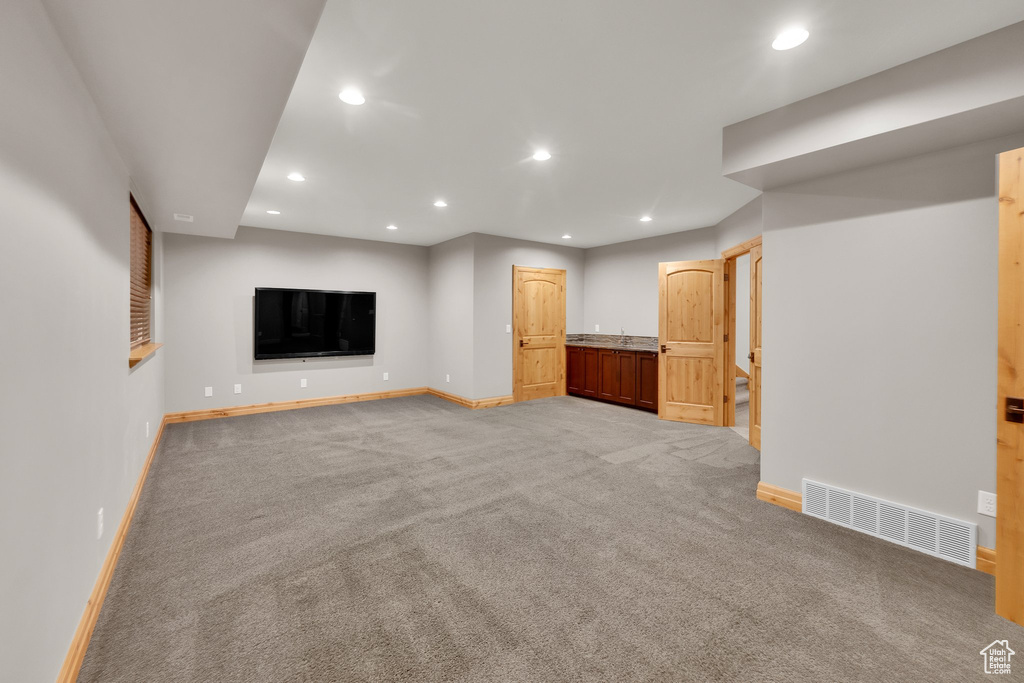 Finished basement with baseboards, recessed lighting, and light carpet
