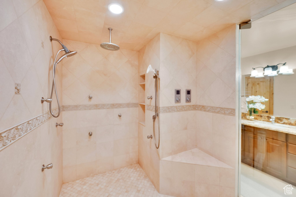 Full bath with vanity, tiled shower, and recessed lighting