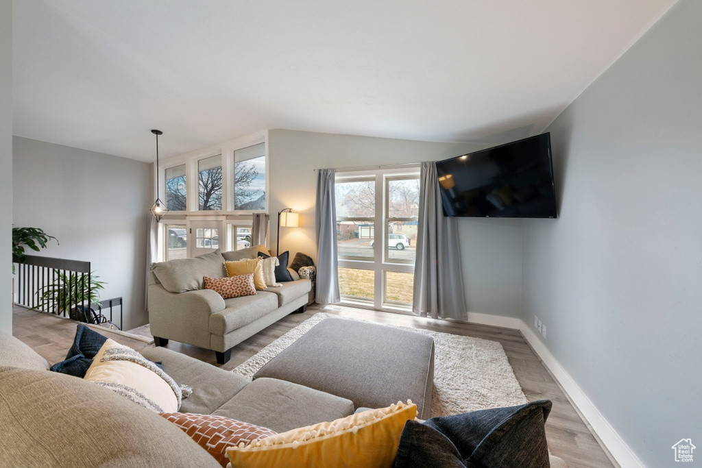 Living room with vaulted ceiling, baseboards, and wood finished floors