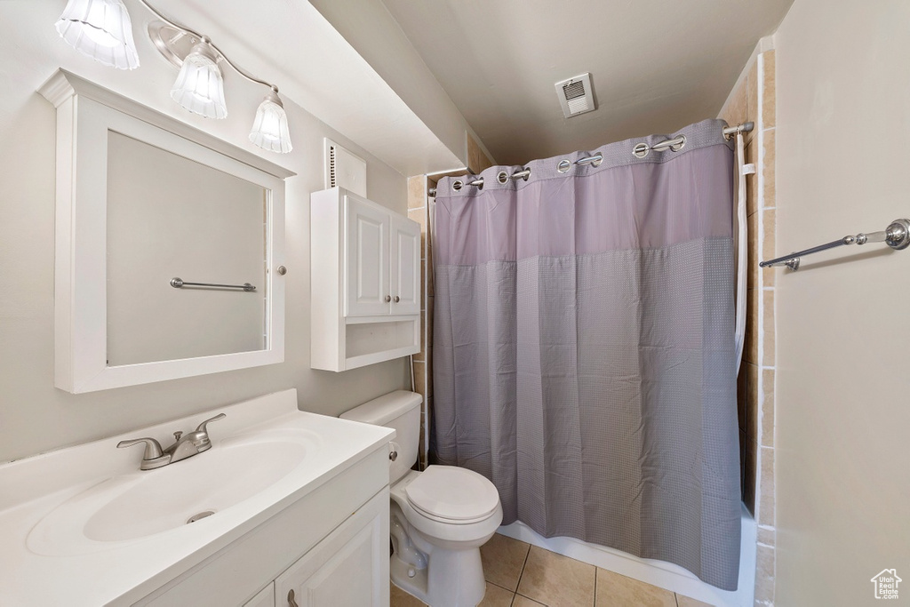 Full bathroom with vanity, toilet, tile patterned flooring, and shower / bath combo with shower curtain