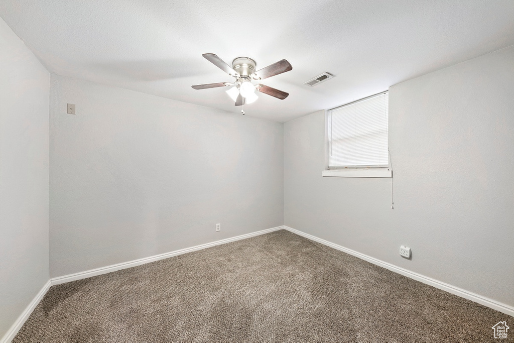 Unfurnished room featuring carpet floors, a ceiling fan, and baseboards