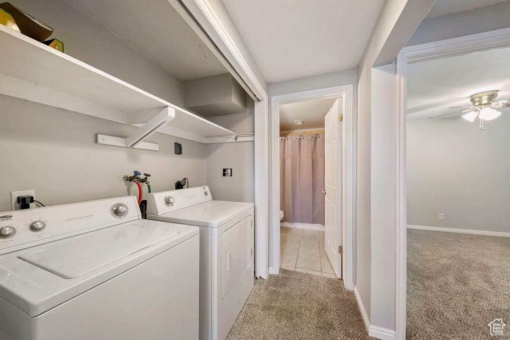 Laundry room featuring light carpet, washing machine and dryer, ceiling fan, and baseboards