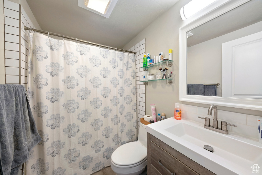Full bathroom featuring tasteful backsplash, vanity, toilet, and a shower with curtain