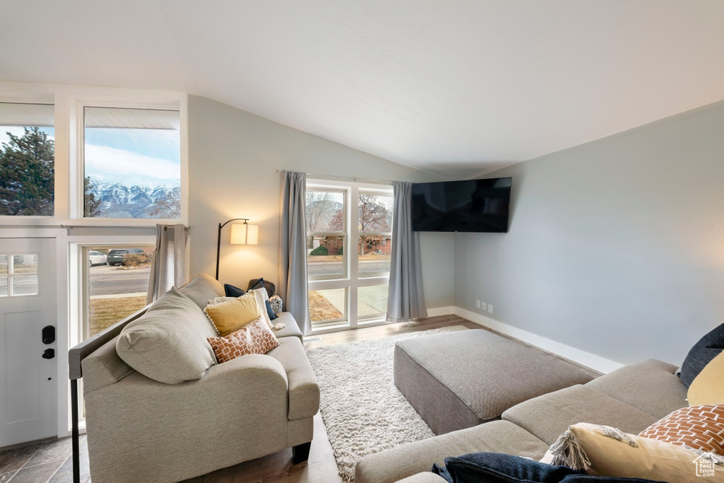 Living room featuring lofted ceiling and baseboards
