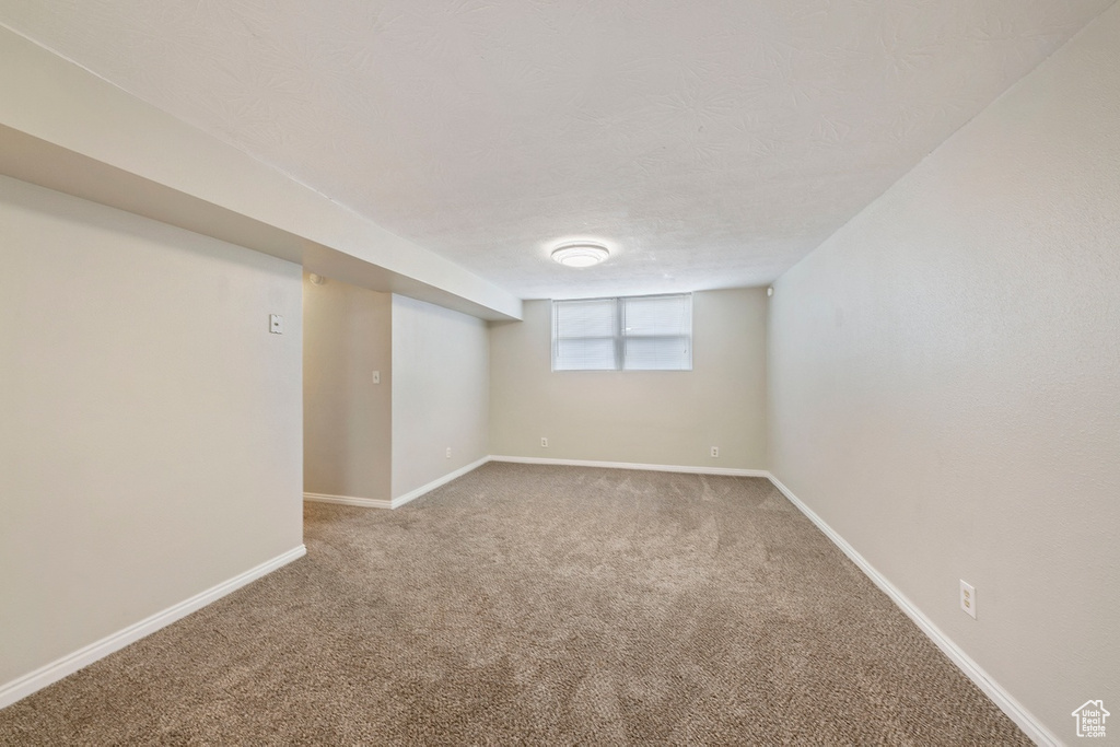 Below grade area with carpet flooring and baseboards