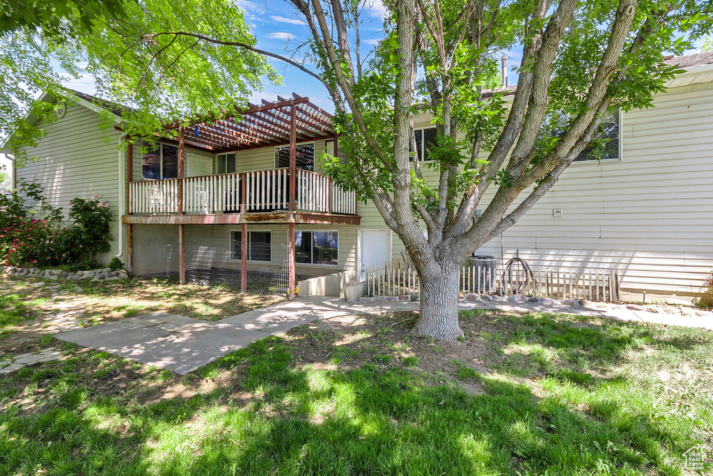 Rear view of property featuring a deck and a patio area
