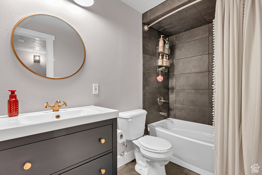 Bathroom featuring toilet, shower / bath combo, vanity, and tile patterned flooring