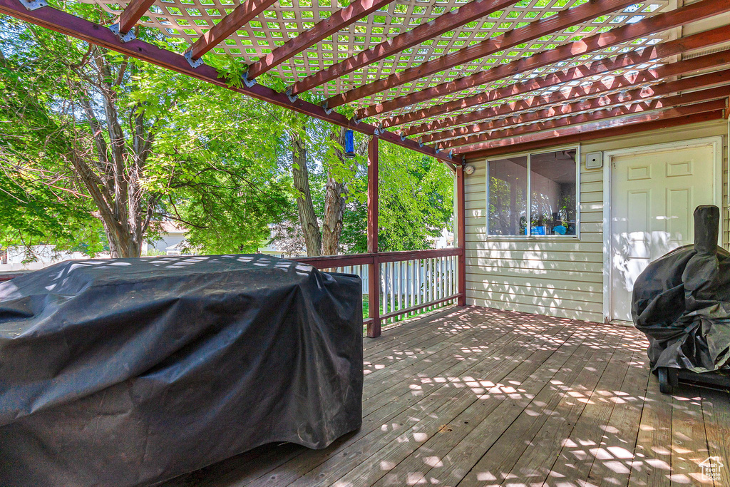 Wooden deck with a grill and a pergola