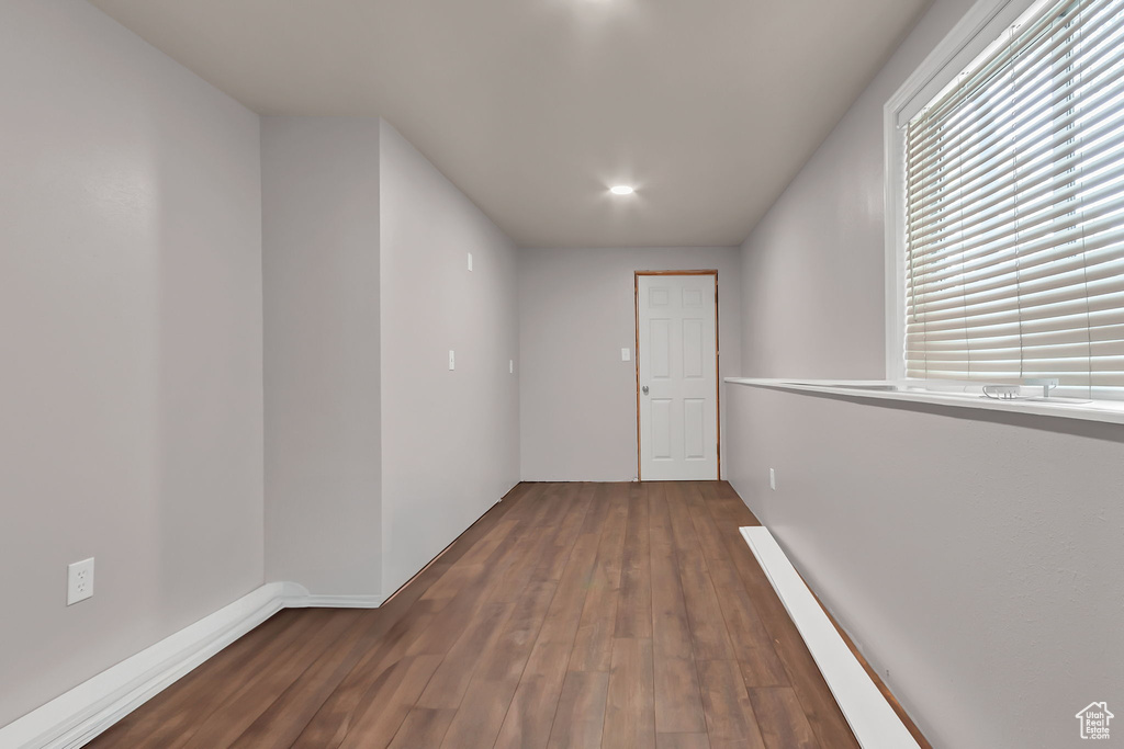 Empty room featuring wood finished floors, baseboards, and recessed lighting