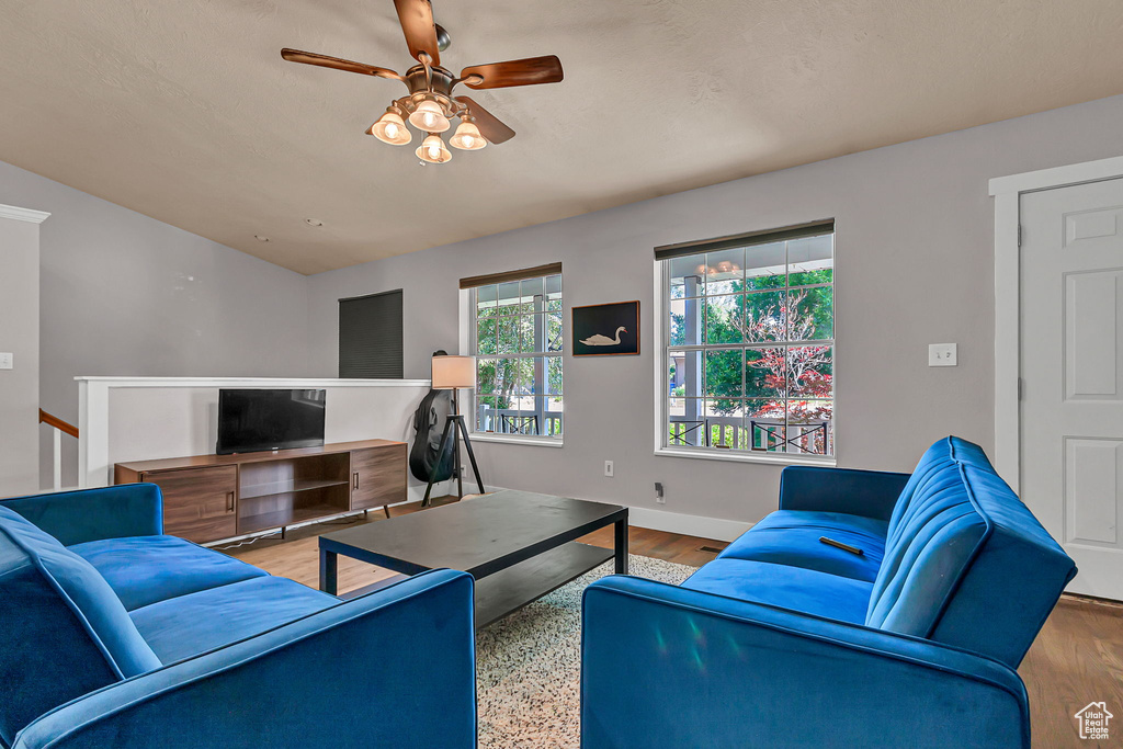 Living room with ceiling fan, baseboards, wood finished floors, and an office area