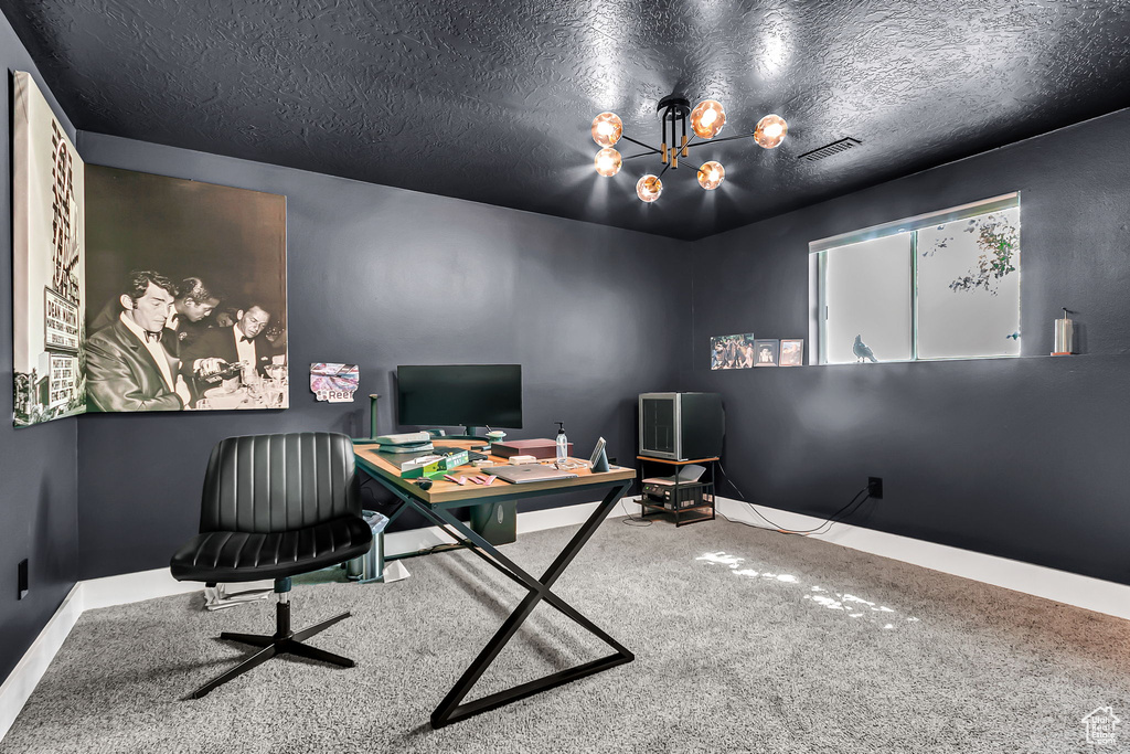 Carpeted office with a chandelier, baseboards, and a textured ceiling