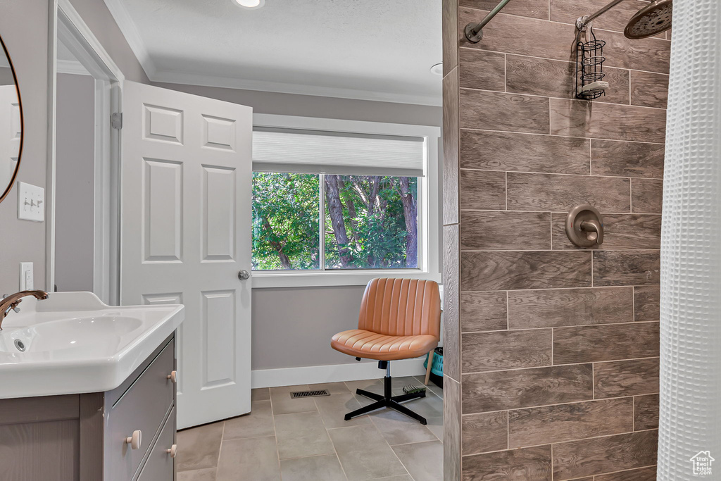Full bath with vanity, a tile shower, and tile patterned floors