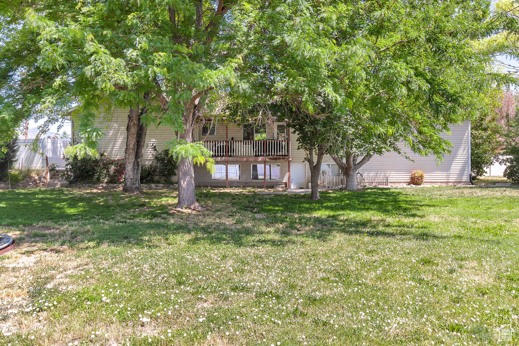 View of grassy yard with a wooden deck