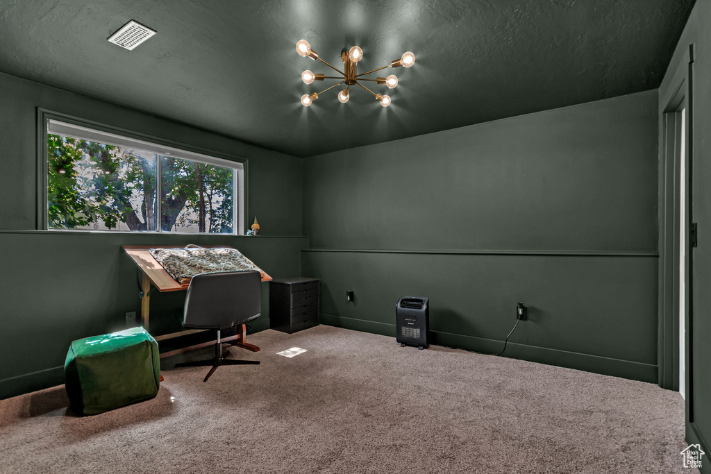 Office area with a chandelier, carpet, and baseboards