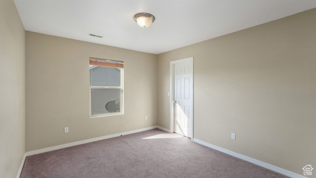 Empty room featuring carpet, baseboards, and healthy amount of natural light