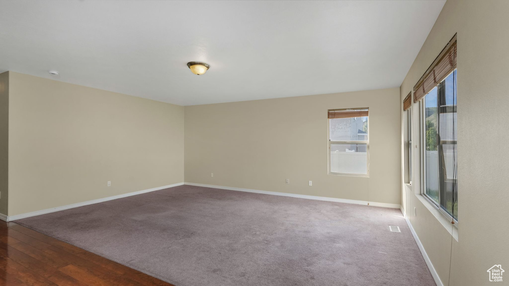 Carpeted spare room featuring baseboards