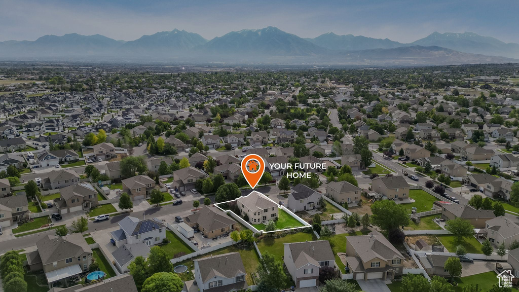Aerial view of property and surrounding area featuring a mountain backdrop and nearby suburban area