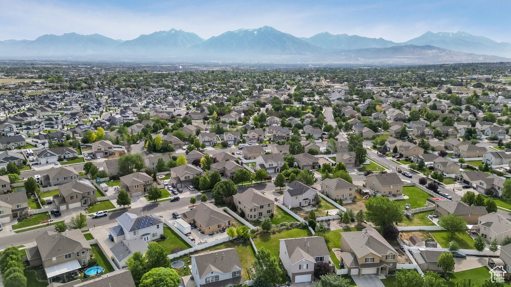 Aerial view of property and surrounding area with a mountain backdrop and nearby suburban area
