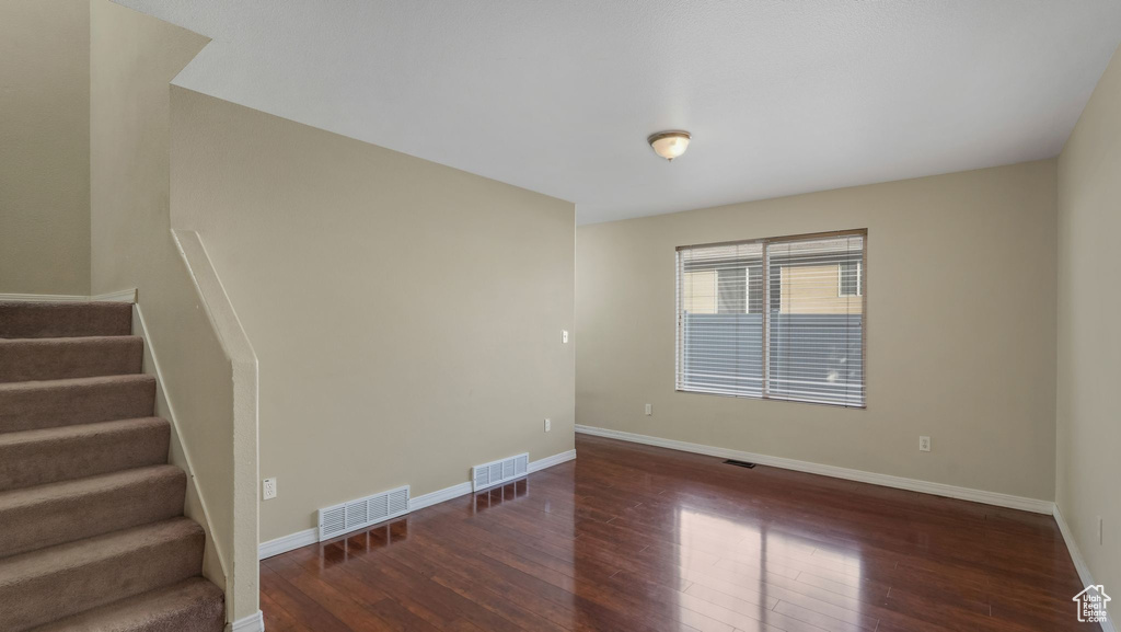 Spare room with hardwood / wood-style flooring, stairway, and baseboards