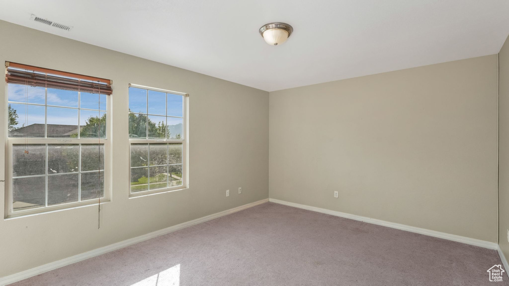 Empty room featuring carpet flooring and baseboards