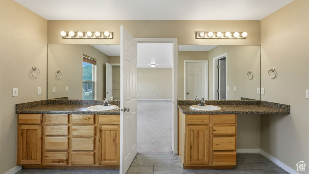 Bathroom with two vanities, baseboards, and tile patterned floors