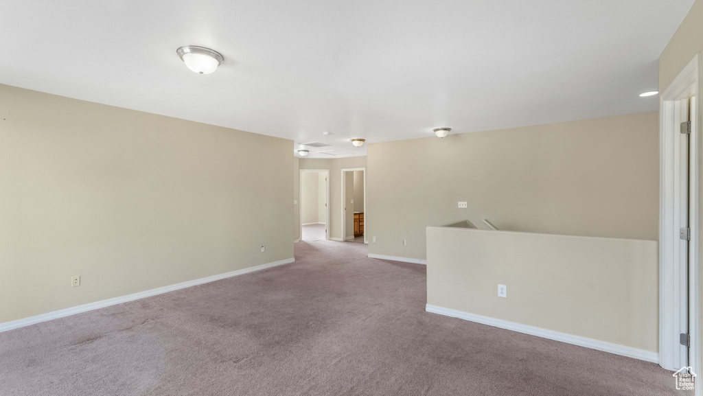 Spare room featuring carpet flooring and baseboards