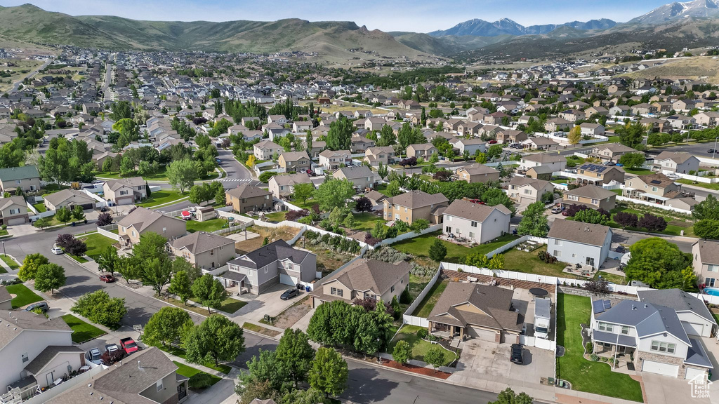 Aerial overview of property's location with a mountainous background and nearby suburban area