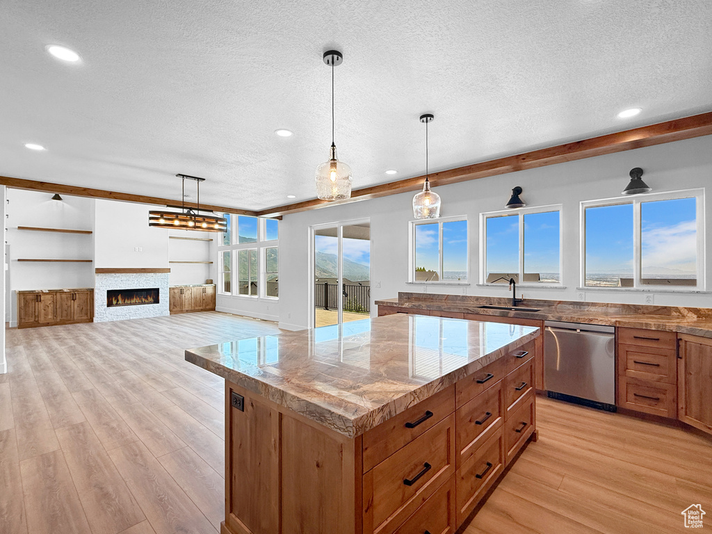 Kitchen with dishwasher, a textured ceiling, light wood finished floors, a sink, and recessed lighting