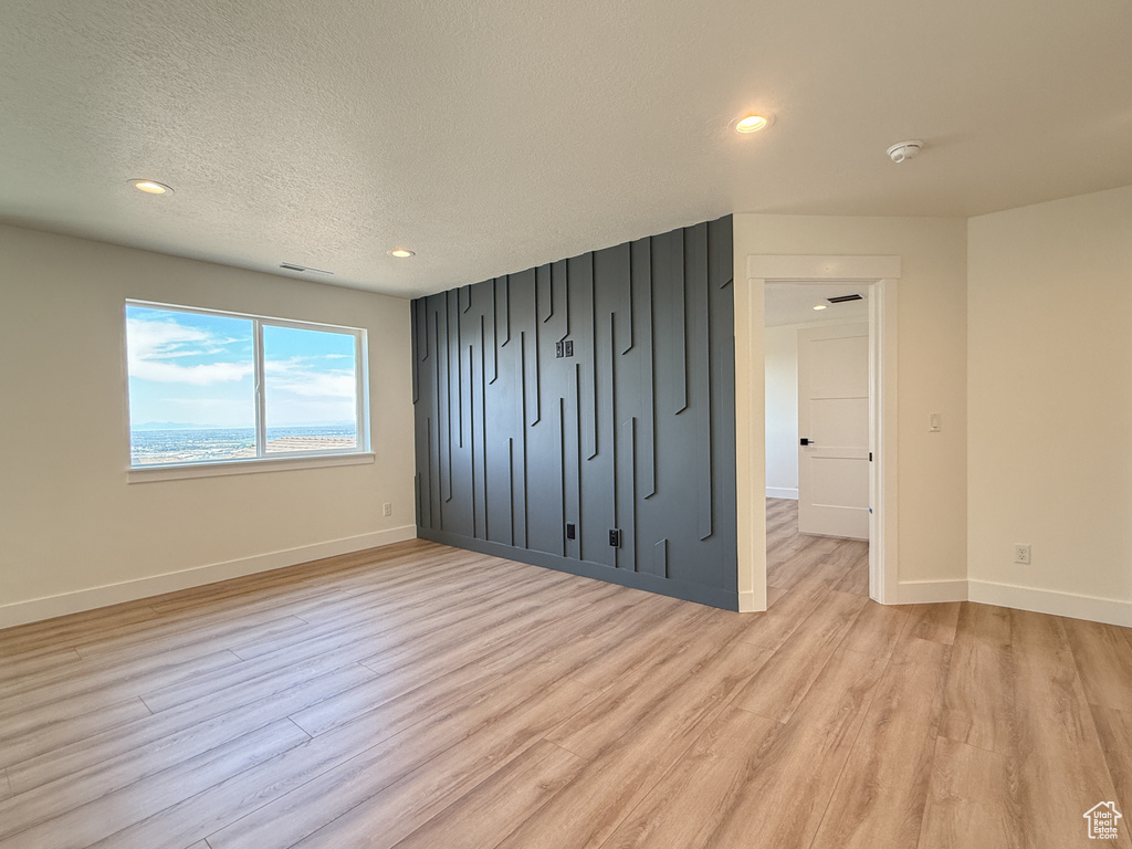 Unfurnished bedroom featuring baseboards, light wood-style flooring, recessed lighting, and a textured ceiling