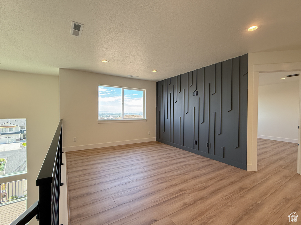 Unfurnished bedroom featuring light wood-style flooring, recessed lighting, baseboards, and a textured ceiling