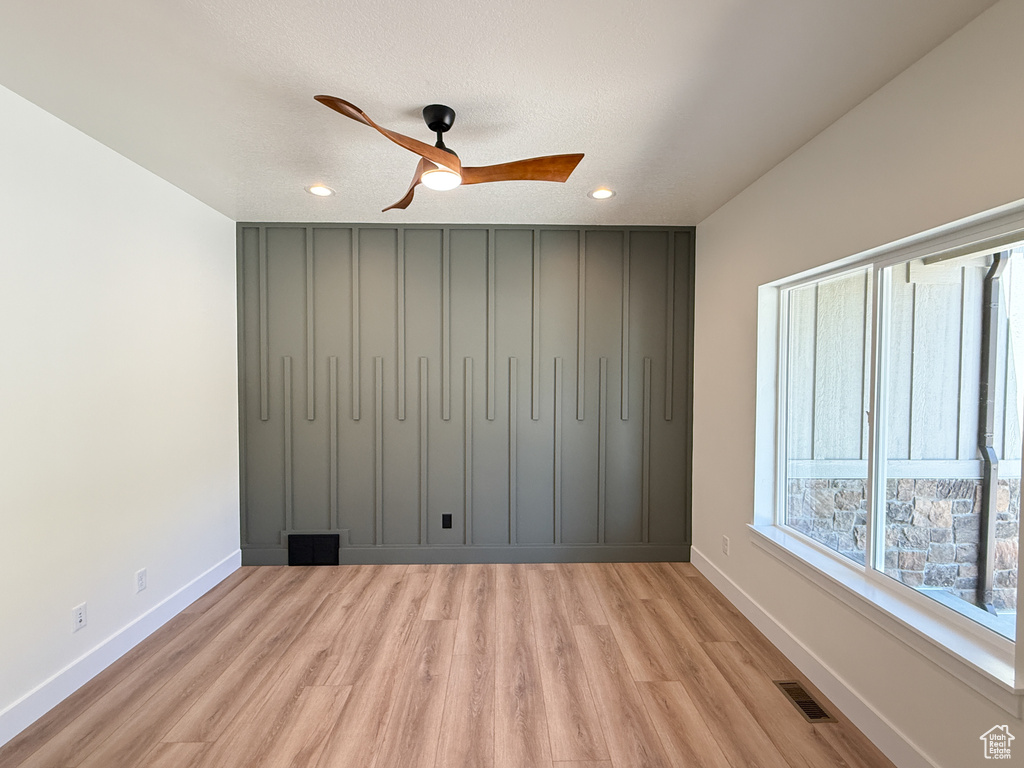 Unfurnished room with light wood-style flooring, ceiling fan, baseboards, and recessed lighting
