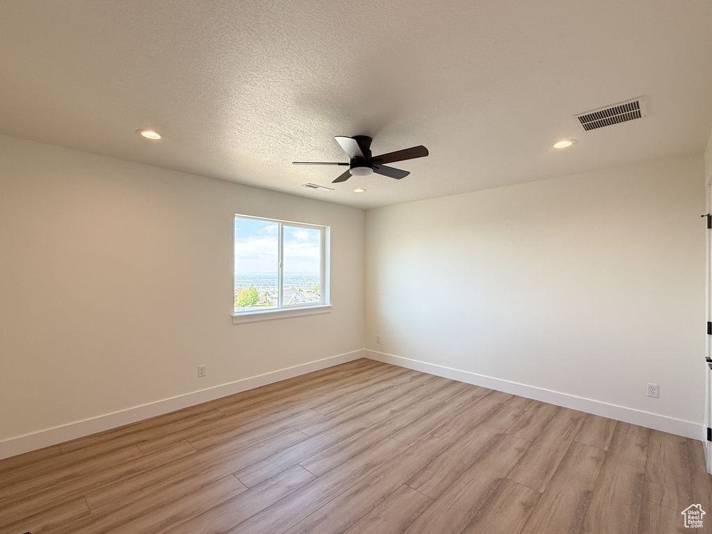 Unfurnished room featuring light wood-style floors, ceiling fan, baseboards, and recessed lighting